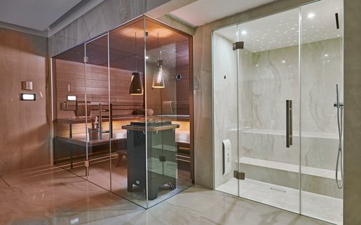 Privater Wellnessbereich: Die Sauna AURA in Nussbaum und das Dampfbad im schlichten, eleganten Design.