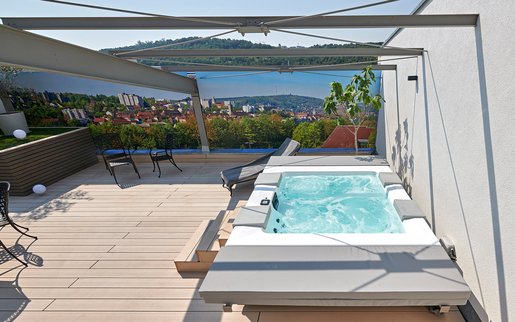 Auf der Terrasse im Whirlpool entspannen: Der von SSF.Pools by KLAFS installierte Whirlpool verfügt über verschiedenen Massagedüsen, Luftmassage und Licht.